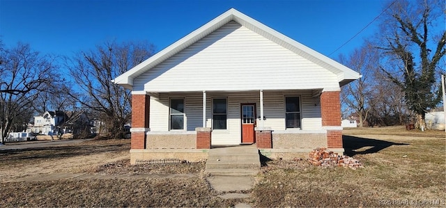 bungalow-style home with a porch and a front lawn