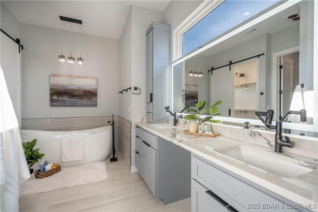 bathroom with tile patterned flooring, a bath, and vanity