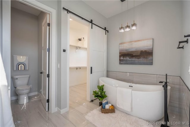 bathroom featuring a washtub, tile patterned floors, and toilet