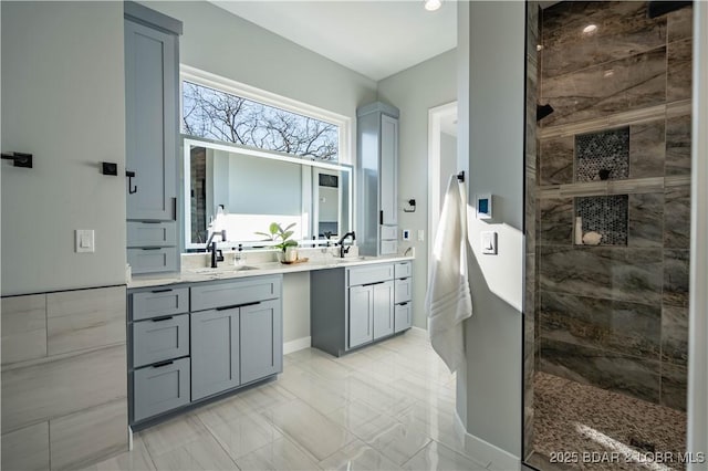 bathroom with vanity and tiled shower