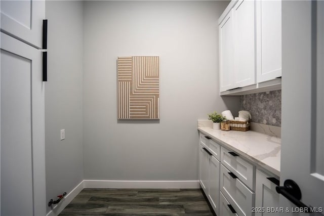 washroom with hookup for a gas dryer, dark hardwood / wood-style floors, and cabinets