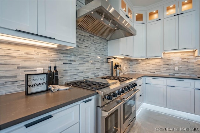 kitchen with range hood, white cabinetry, double oven range, and tasteful backsplash