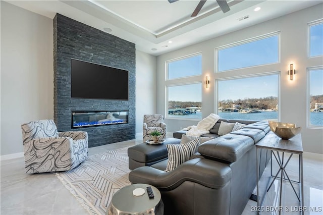 living room with ceiling fan and a stone fireplace