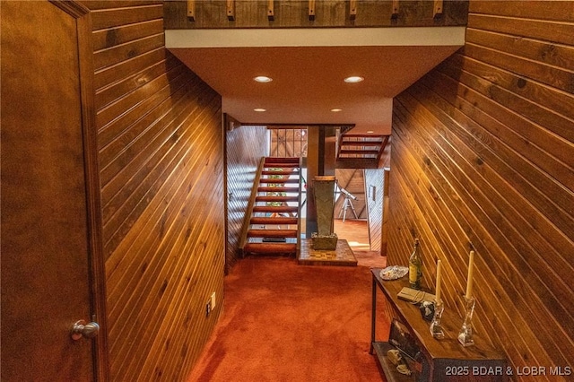 stairs with wooden walls and carpet floors