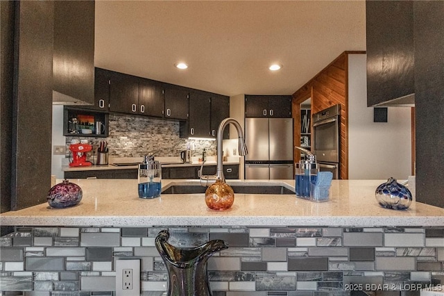 kitchen with sink, backsplash, a breakfast bar area, and appliances with stainless steel finishes