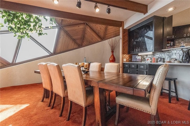 dining area with carpet floors and lofted ceiling with beams