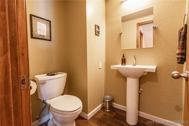 bathroom with sink, hardwood / wood-style floors, and toilet