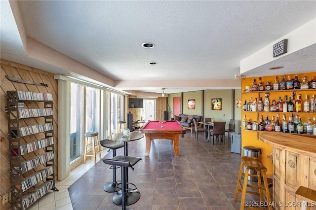 game room featuring bar, a textured ceiling, and pool table