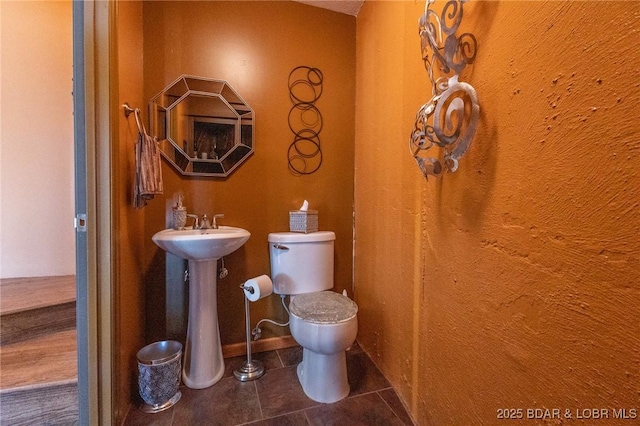 bathroom with toilet and tile patterned floors