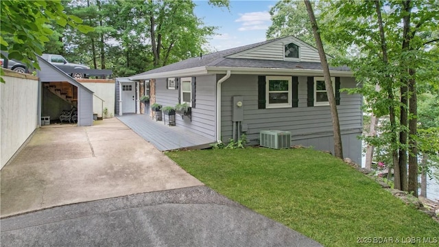 view of front of property with cooling unit, a front lawn, and a storage unit