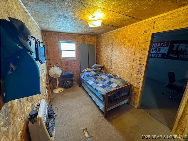 carpeted bedroom featuring ornamental molding and heating unit