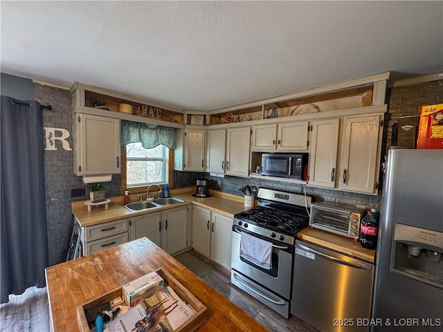 23731 Grant Rd, Barnett, MO 65011 - kitchen with stainless steel appliances, light countertops, wood finished floors, a textured ceiling, and backsplash