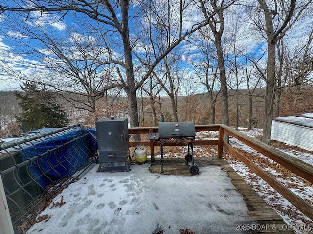 snow covered deck with a grill