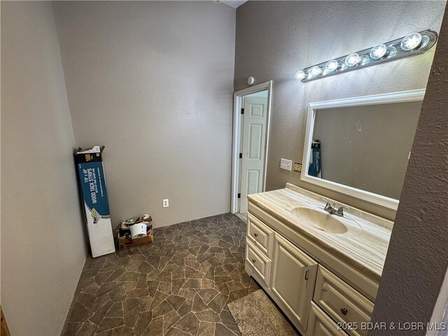 bathroom with stone finish flooring and vanity