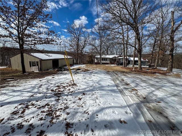 yard layered in snow with an outbuilding