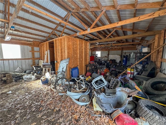 miscellaneous room featuring a garage, metal wall, and lofted ceiling