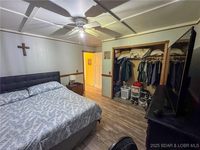 bedroom with ceiling fan, a closet, and wood finished floors