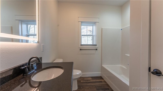 full bathroom featuring toilet, vanity, wood-type flooring, and bathtub / shower combination