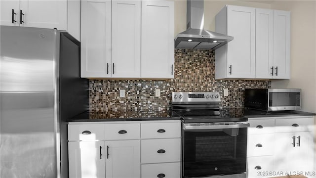 kitchen featuring stainless steel appliances, wall chimney exhaust hood, white cabinets, and tasteful backsplash