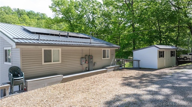 rear view of property featuring a storage unit