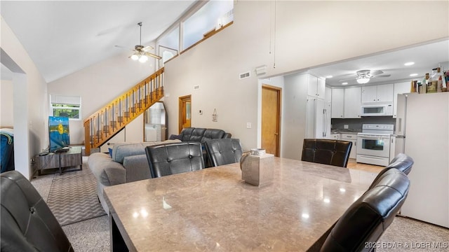 dining space featuring high vaulted ceiling and ceiling fan