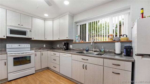 kitchen with light hardwood / wood-style floors, sink, white appliances, and ceiling fan