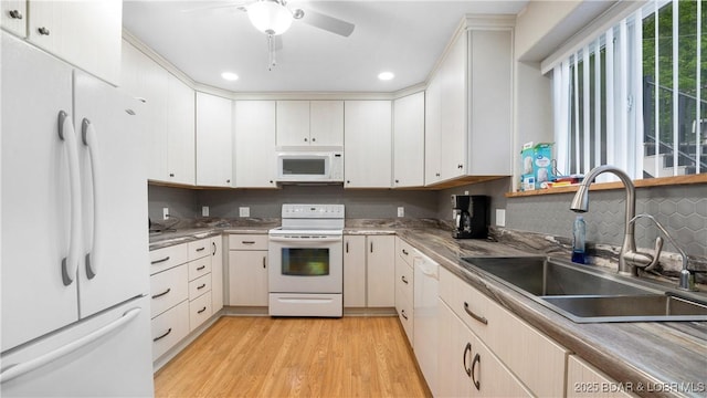 kitchen featuring white appliances, white cabinetry, sink, light wood-type flooring, and ceiling fan