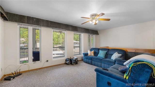 living room featuring ceiling fan, carpet, and a wealth of natural light