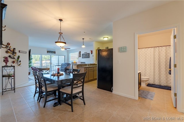 dining space featuring sink and light tile patterned flooring