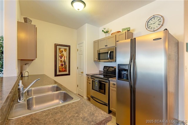 kitchen featuring appliances with stainless steel finishes, light brown cabinetry, and sink