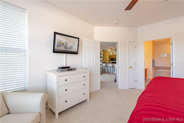 bedroom with ensuite bathroom, ceiling fan, light carpet, and multiple windows