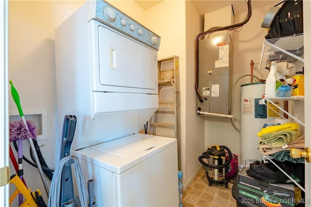 washroom featuring stacked washer / dryer and water heater