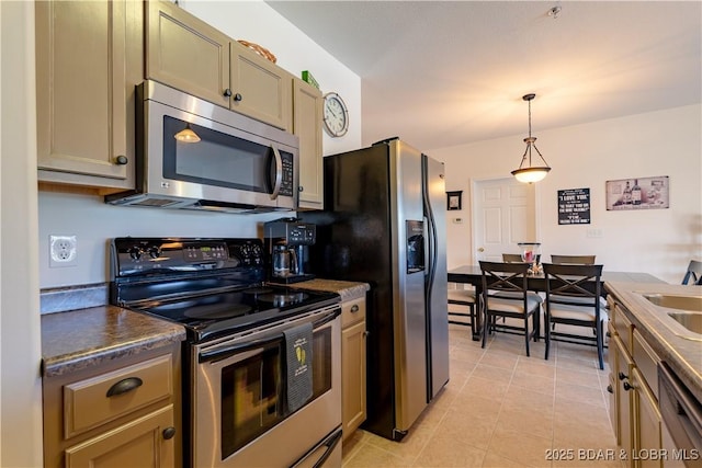 kitchen featuring light tile patterned flooring, stainless steel appliances, hanging light fixtures, and sink