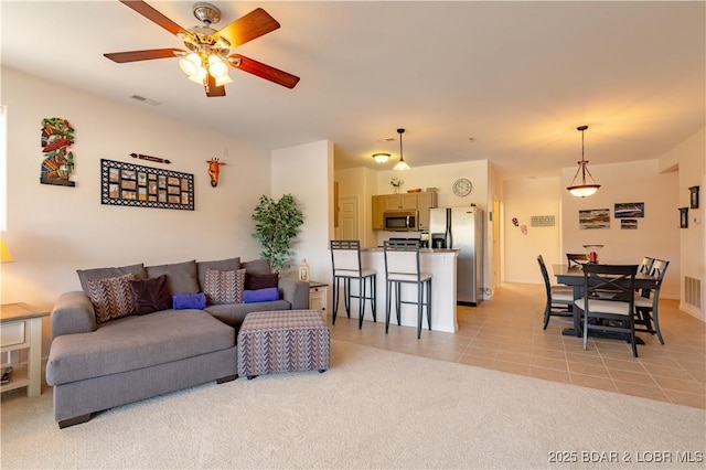 living room featuring ceiling fan and light tile patterned flooring