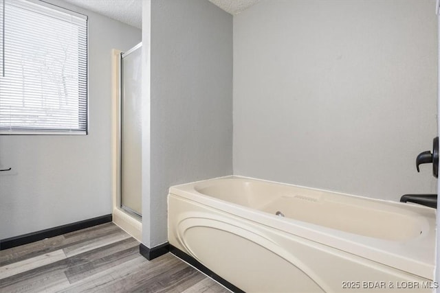 65 Laguna Dr Unit 1A/757, Lake Ozark, MO 65049 - bathroom featuring a garden tub, a textured ceiling, a stall shower, and wood finished floors