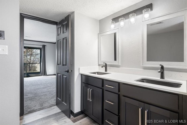 bathroom with hardwood / wood-style flooring, vanity, and a textured ceiling