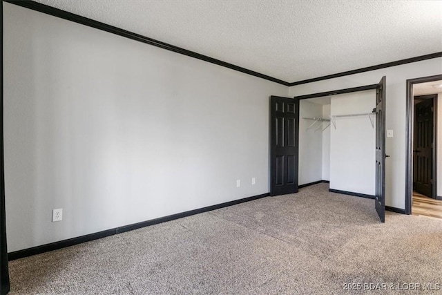 unfurnished bedroom featuring crown molding, a closet, a textured ceiling, and carpet