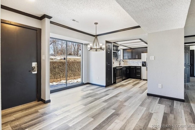 65 Laguna Dr Unit 1A/757, Lake Ozark, MO 65049 - kitchen with appliances with stainless steel finishes, a chandelier, light countertops, a textured ceiling, and ornamental molding
