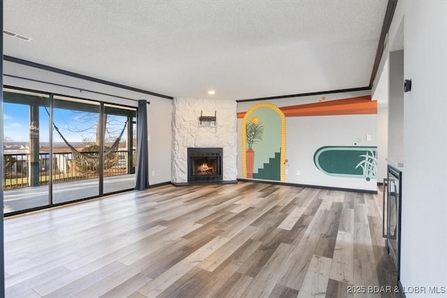 65 Laguna Dr Unit 1A/757, Lake Ozark, MO 65049 - unfurnished living room featuring wood finished floors, crown molding, a fireplace, a textured ceiling, and recessed lighting