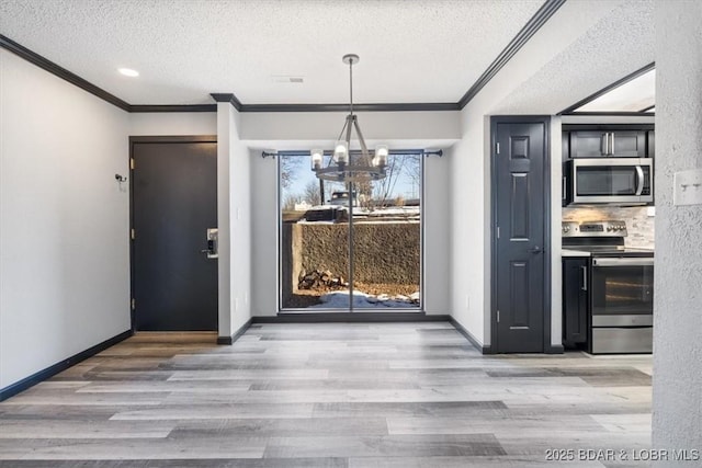 unfurnished dining area with ornamental molding, a textured ceiling, and light hardwood / wood-style floors