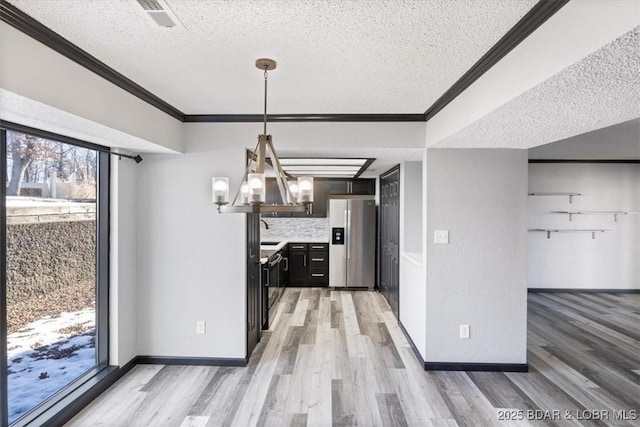 interior space featuring wood-type flooring, stainless steel fridge with ice dispenser, hanging light fixtures, a textured ceiling, and ornamental molding