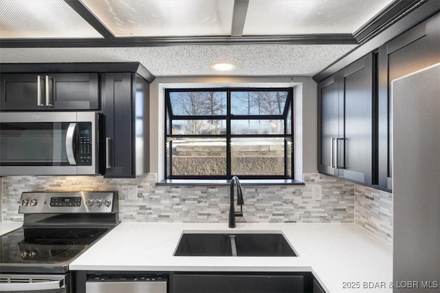 kitchen with tasteful backsplash, sink, and appliances with stainless steel finishes