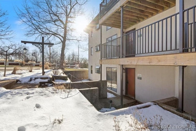 view of snow covered exterior featuring a balcony