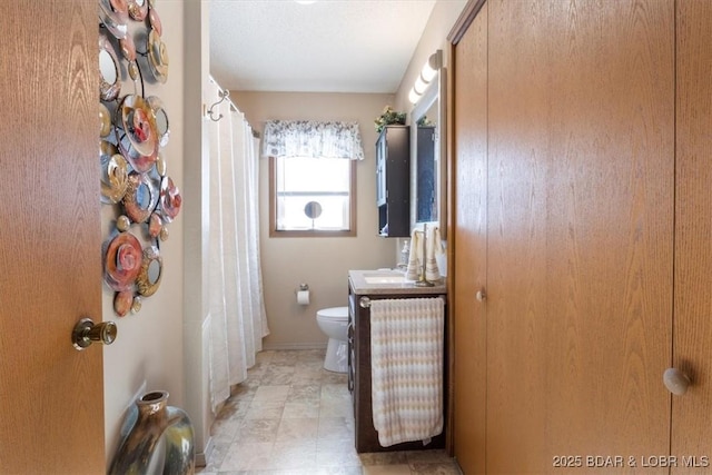 bathroom with toilet, vanity, and curtained shower