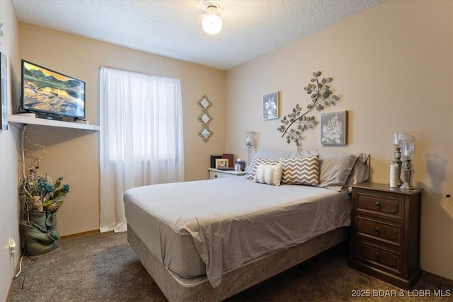 bedroom with a textured ceiling and dark colored carpet