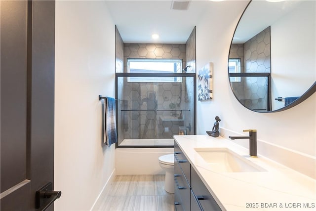 full bathroom featuring combined bath / shower with glass door, vanity, and toilet