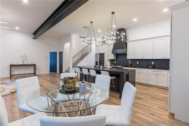 dining room with beam ceiling and light wood-type flooring