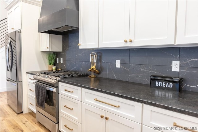 kitchen featuring ventilation hood, appliances with stainless steel finishes, white cabinets, and backsplash