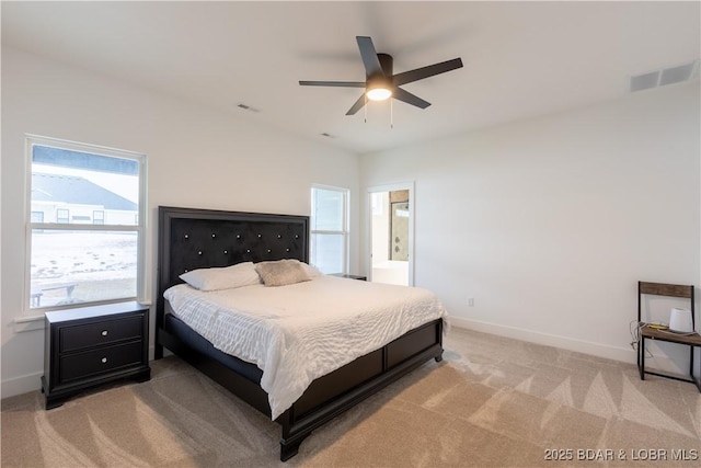 carpeted bedroom with ceiling fan and ensuite bath