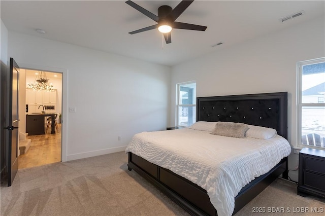 carpeted bedroom featuring ceiling fan and multiple windows